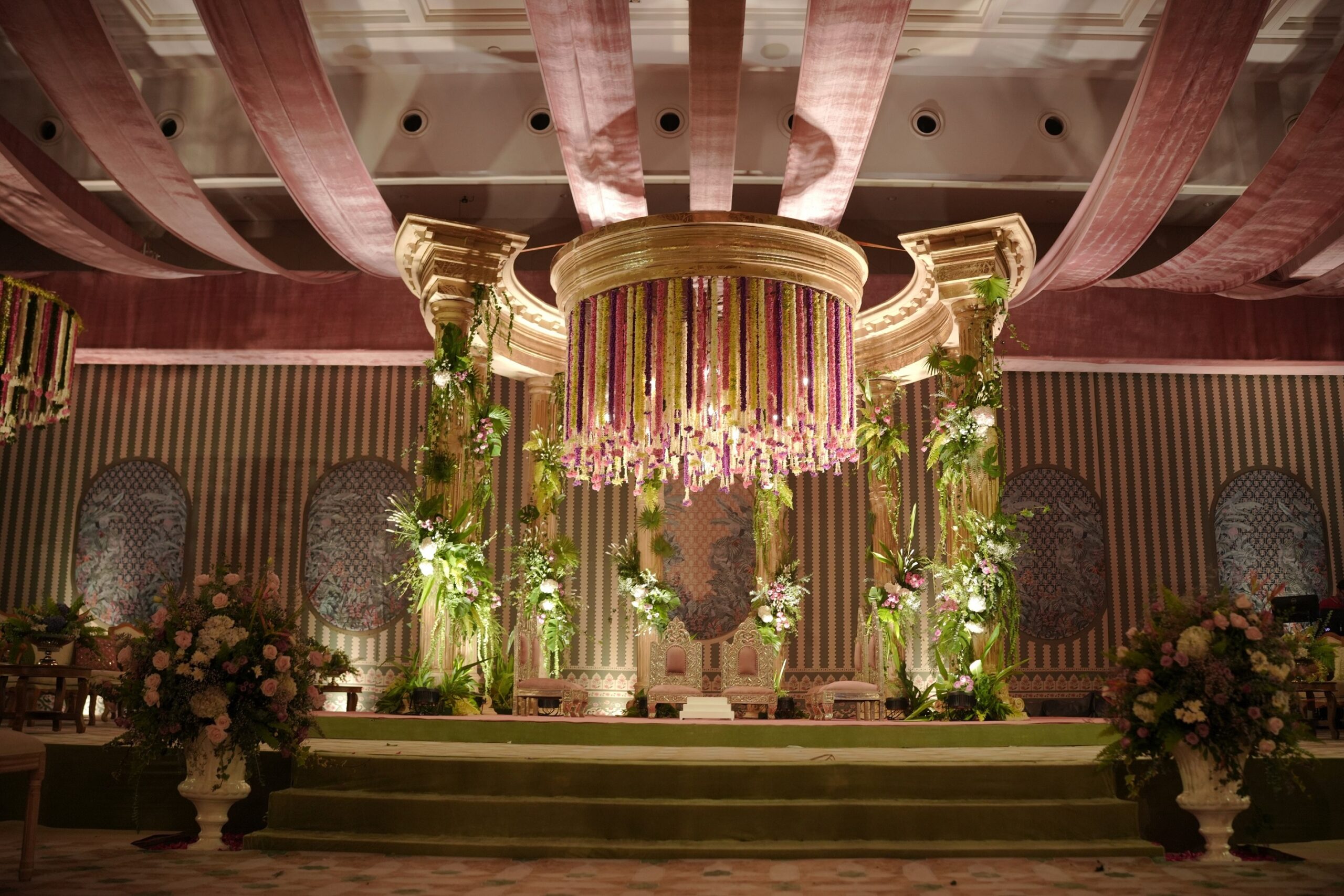 varmala stage with beautiful hanging flowers below a circular dome